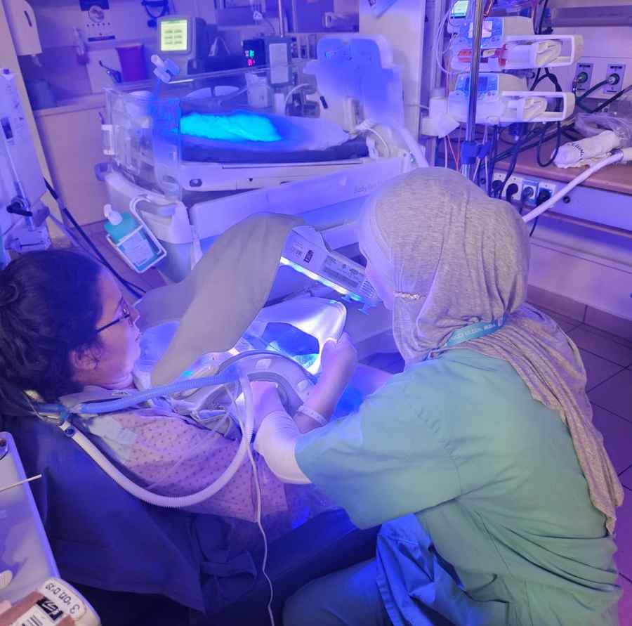 A nurse caring for a baby in prolonged skin-to-skin care during phototherapy
